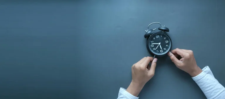 manos de un trabajador sujetando reloj para mirar las horas extra que lleva trabajando